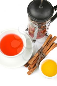 Cup of hot berries tea with cinnamon sticks, and honey