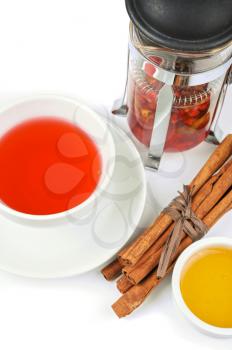 Cup of black tea from cowberry and mint with cinnamon sticks, and honey