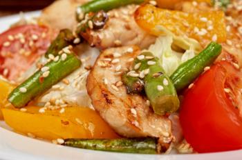 Warm salad with chicken, vegetable and sesame seeds