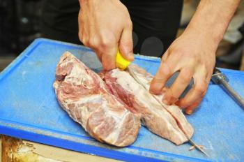 cutting a piece of fresh pork meat