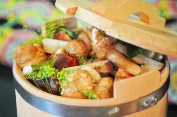 preserved mushrooms with vegetables in wooden jar