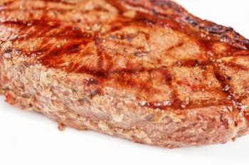 Juicy rib-eye beef steak on a white plate