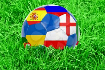 Soccer ball on grass field background. Ball filled with euro 2012 countries flags colors.