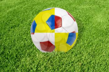 Soccer ball colored by flag of Poland and Ukraine at green grass
