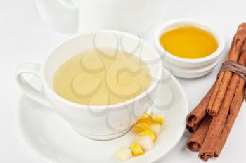 Cup of hot linden tea with cinnamon sticks, and honey