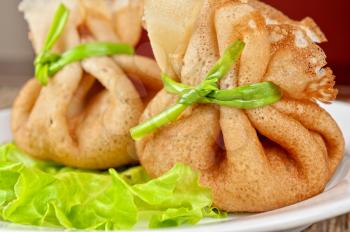tasty pancakes stuffed with meat served with lettuce and green onion