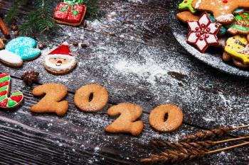 Gingerbreads cookies for New 2020 Year and christmas on wooden background, xmas theme