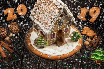 Gingerbread house and figures with lights on dark background, xmas theme