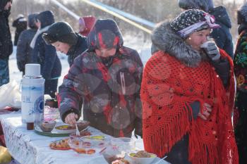 SVETLOE LAKE. ALTAISKIY KRAI. WESTERN SIBERIA. RUSSIA - DECEMBER 2, 2018: People drink tea and try national dishes in the Altaiskaya Zimovka holiday - the first day of winter on December 2, 2018 in Altayskiy krai, Siberia, Russia.