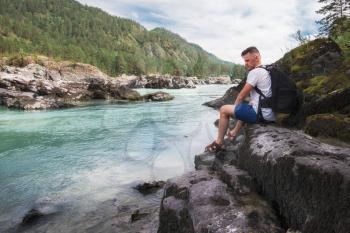 Man resting at river in Altai Mountains territory