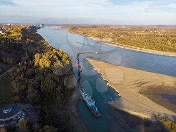 Cleaning and deepening by a dredger on the river. Ob river, Siberia, Russia