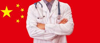 Male doctor on China flag background. Concept of corona virus.
