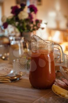 Decorated table with jug of juice on foreground