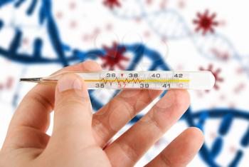 Hand with a medical thermometer on COVID-19 background. Concept of corona virus.
