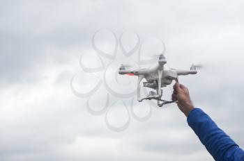 The flying drone copter with digital camera and human hand