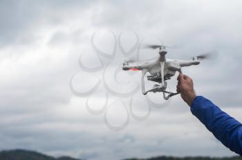 The flying drone copter with digital camera and human hand