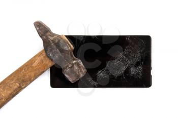 An old hammer and smartphone with broken screen on a white background
