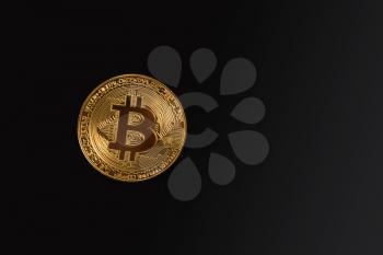 Golden Bitcoin coin on the black background