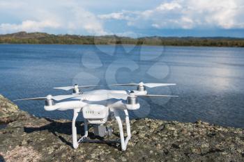 The drone copter with digital camera ready to flying on lake background