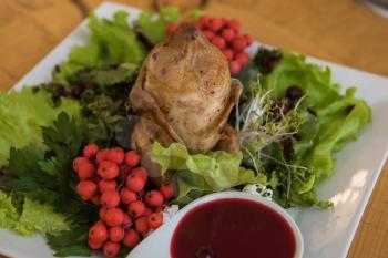 quail roasted with sweet and sour cranberry sauce decorated with rowanberry