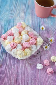 Tasty different marshmallows with chamomile flower on a color gradient background