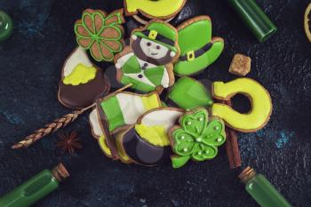 Homemade gingerbreads cookies for Patrick's day on dark stone background