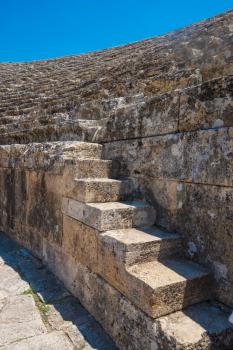 Closeup photo of steps of Roman amphitheatre in the ruins of Hierapolis, in Pamukkale, near modern turkey city Denizli, Turkey.