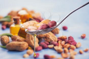 Natural peanut oil with spoon and nuts