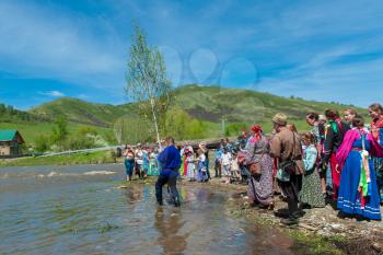 TOPOLNOE, ALTAY, RUSSIA - May 27, 2018: Folk festivities dedicated to the feast of the Holy Trinity. Ancient Russian rite: sinking a birch.