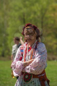 TOPOLNOE, ALTAY, RUSSIA - May 27, 2018: Folk festivities dedicated to the feast of the Holy Trinity. Happy old woman in traditional dress