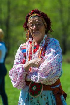 TOPOLNOE, ALTAY, RUSSIA - May 27, 2018: Folk festivities dedicated to the feast of the Holy Trinity. Happy old woman in traditional dress
