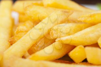 Golden potatoes fries in the plate closeup