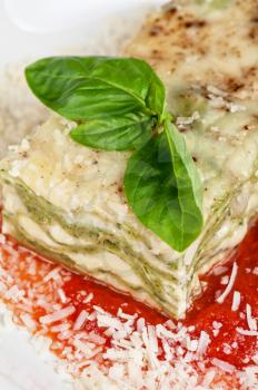 Portion of lasagna garnished with salad greens