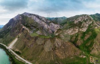 Beauty day in the mountains in Altay. Road, river and mountains. Aerial shot on drone