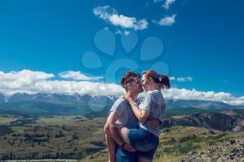 Loving couple together on Altai mountain looking at a view