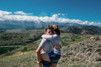 Loving couple together on Altai mountain looking at a view
