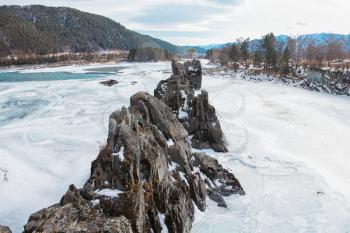Fast mountain river Katun in Altay, Siberia, Russia. A popular tourist place called the Dragon's Teeth. Beauty sunny winter day.