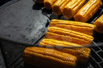 A professional cook prepares corn on the grill outdoor, food or catering concept