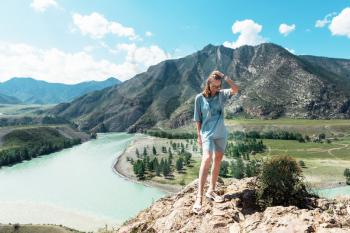 Domestic tourism, travel, lesure and freedom concept: woman on the confluence of two rivers Katun and Chuya in Altai mountains, beauty summer day