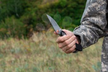 A man with a knife in the forest. Travel or military concept