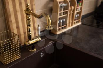 Photo of new modern kitchen interior. Luxury gold water tap