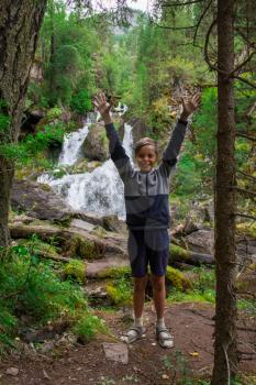 Young boy at waterfall in Altai Mountains territory
