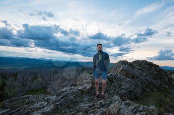 Travel, freedom and tourism concept - man standing on top of cliff in summer beauty evening in Altai mountains
