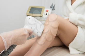 Laser epilation of legs, hair removal cosmetology procedure. Health and beauty concept.