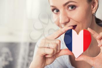 Young woman with gingerbread heart cookies with flag of France