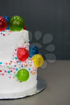 Wedding cake with caramel balloons on grey background