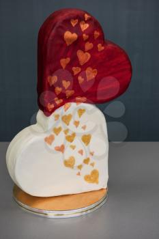 Wedding cake as two hearts on grey background