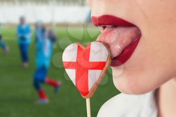 Closeup photo of the woman lips and cookie hearts with flag of England
