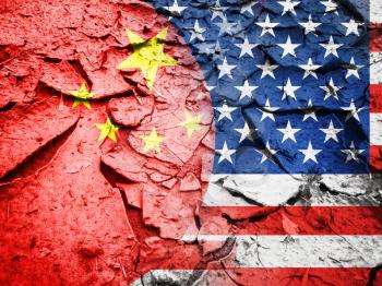 Trade war concept, USA flag against China flag, on dry cracked earth background