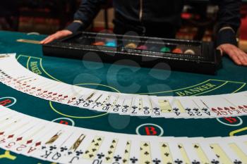 Professional croupier during cards shuffle in the casino